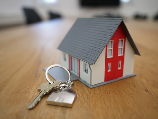 little model of house with a house key next to it