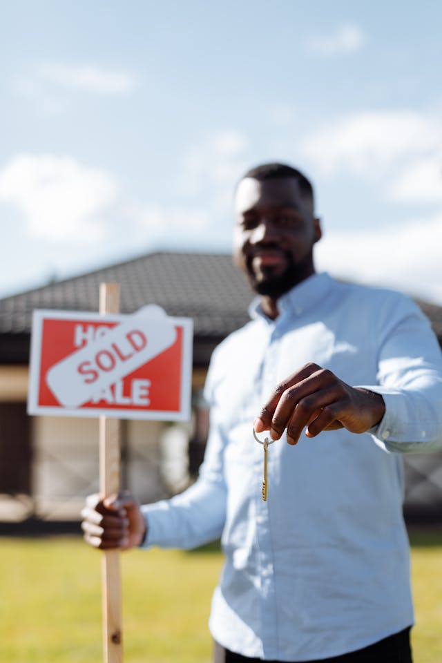 man holding sold sign