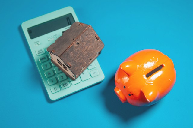 piggy bank calculator and a small house